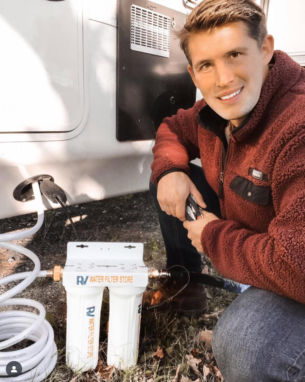 Man kneeling next to an RV water filter system