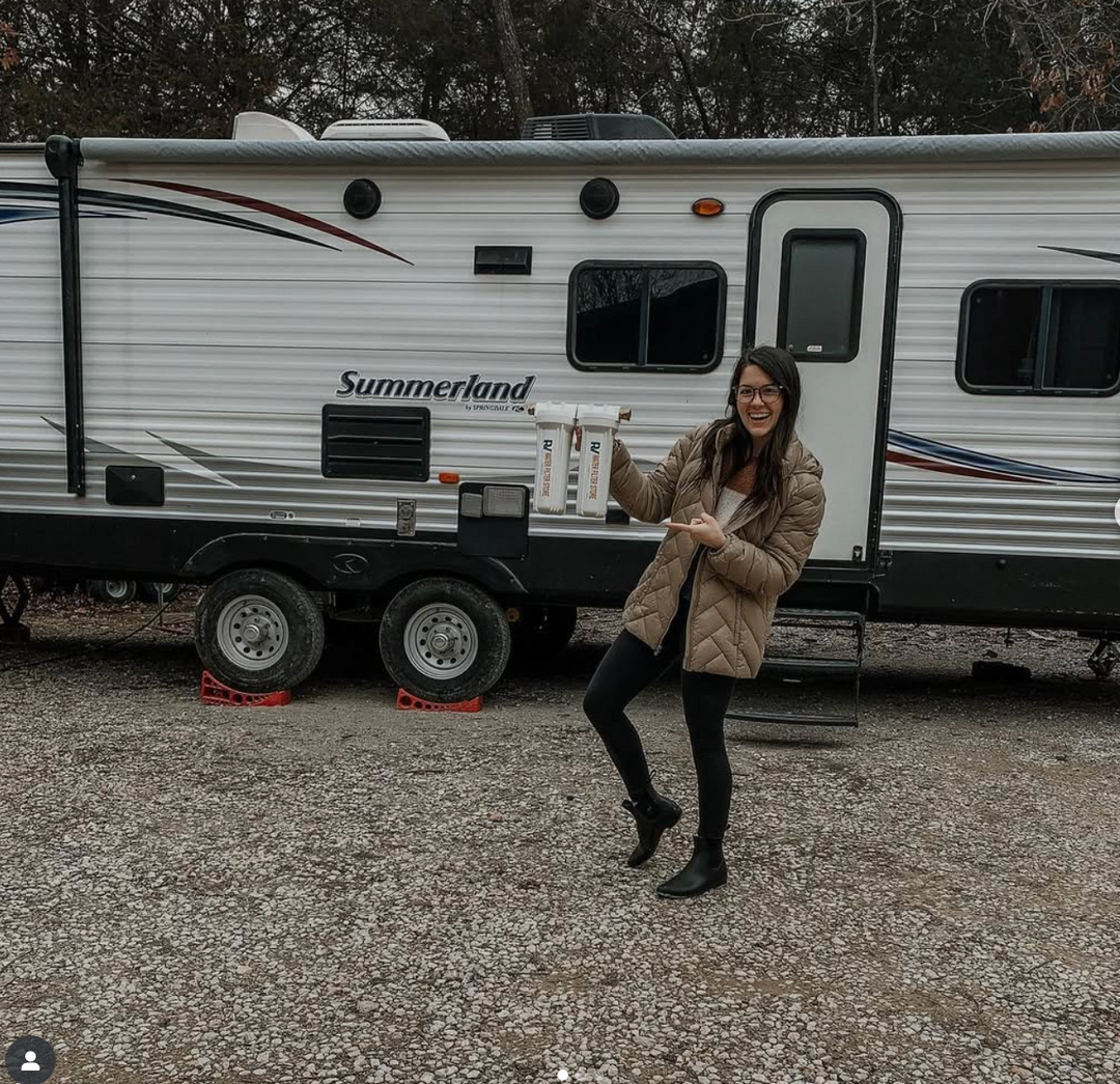Woman standing in front of a Summerland travel trailer