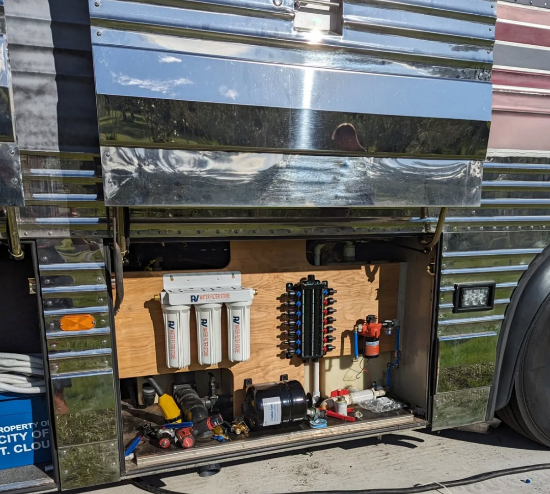 Metal storage locker with open door revealing various equipment and tools inside.