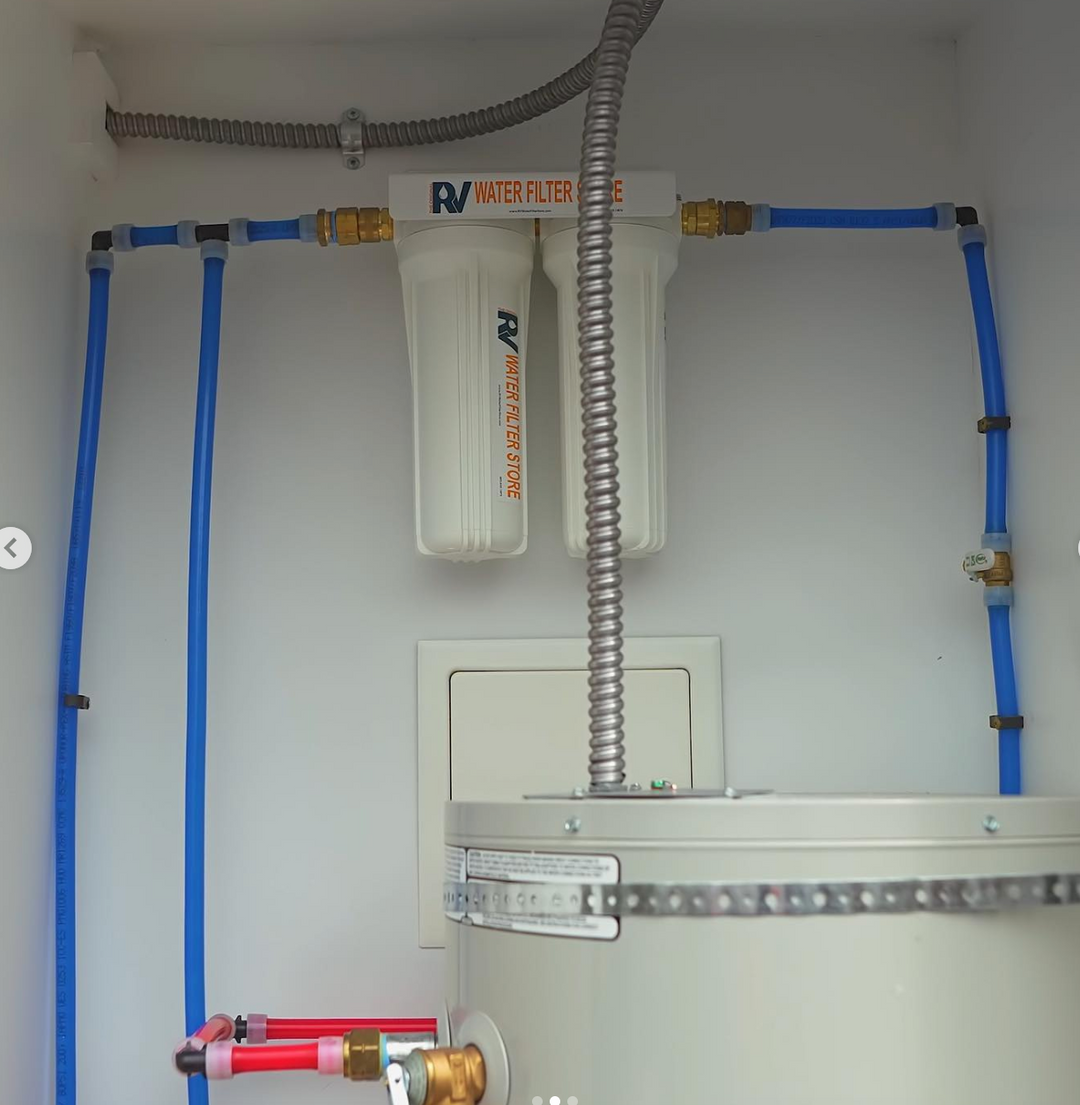 RV water filter system with blue and red hoses on a white wall.